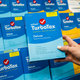 A hand holds up a box containing TurboTax deluxe software.